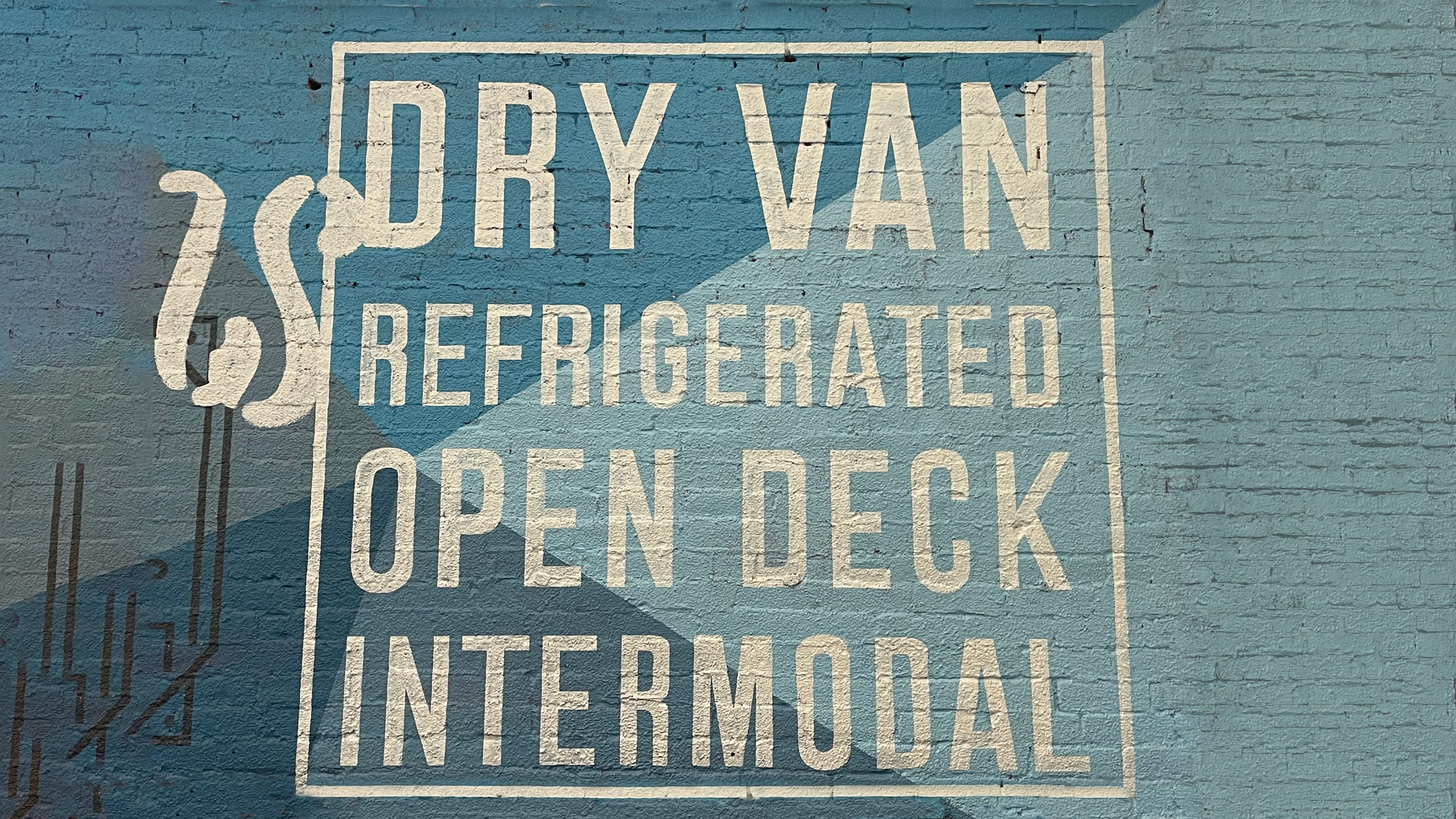 a blue wall mural on brick that mentions open deck.